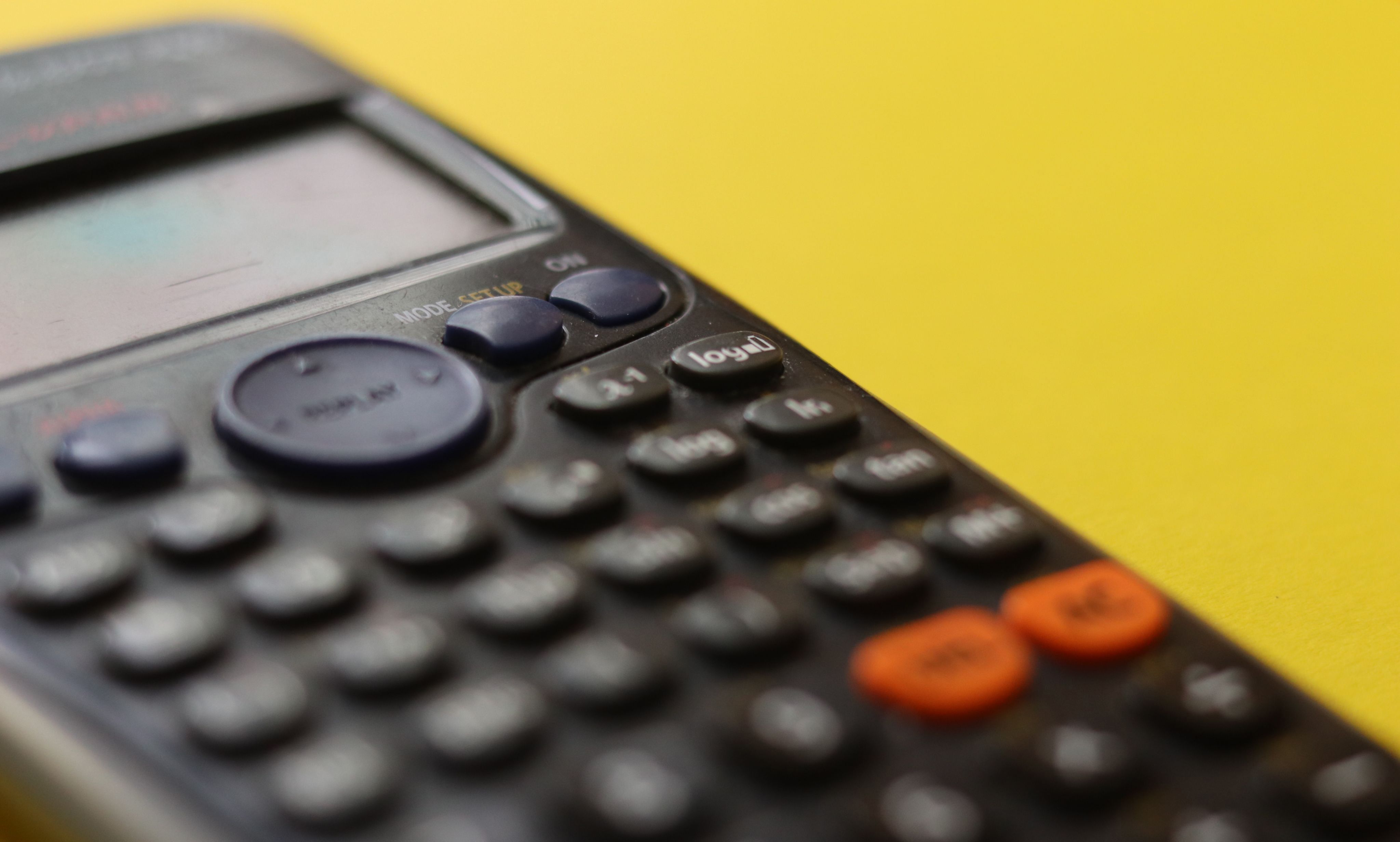 Black calculator on a yellow background
